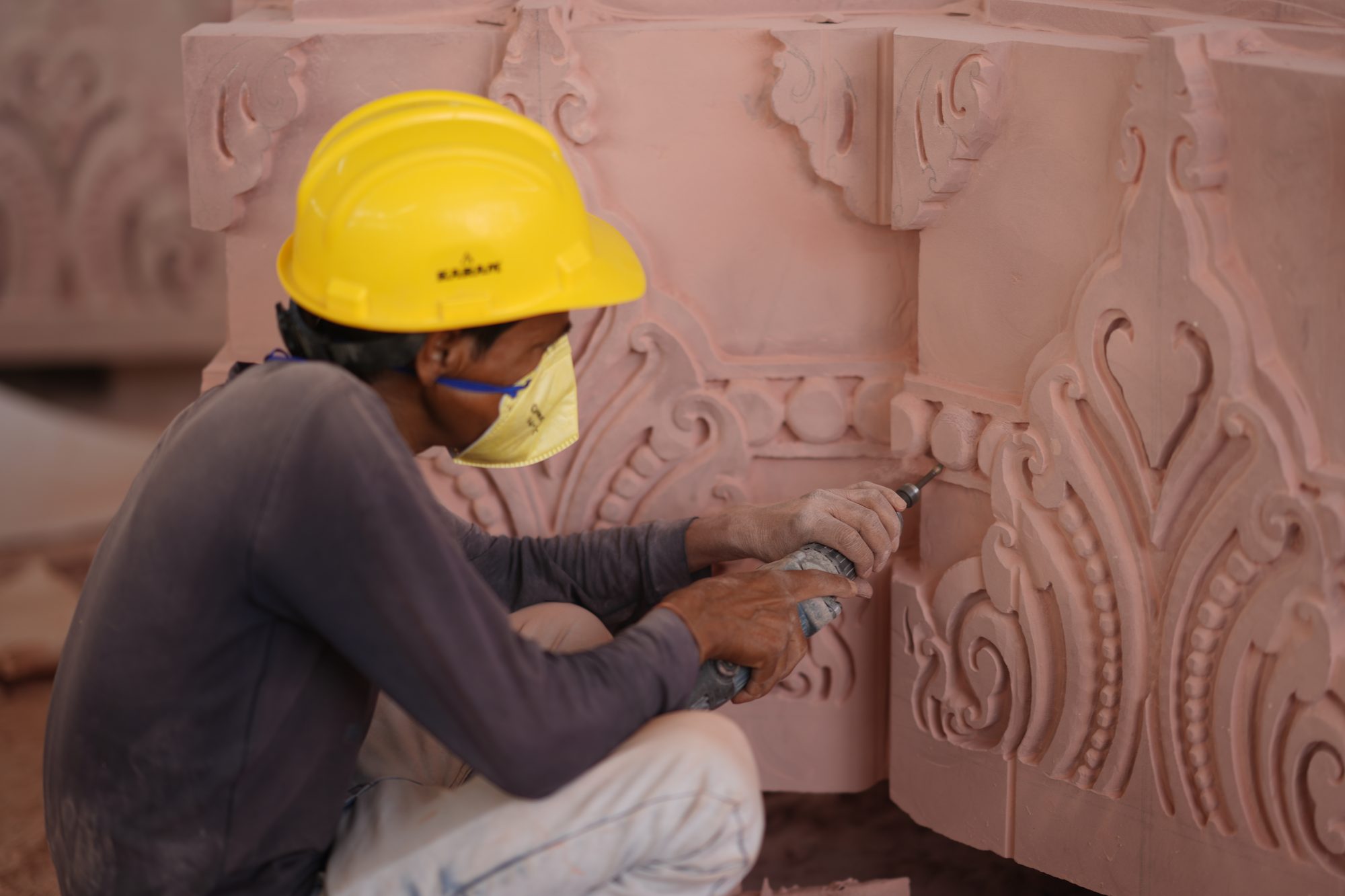 Master craftsman detailing an ornate sandstone arch by hand