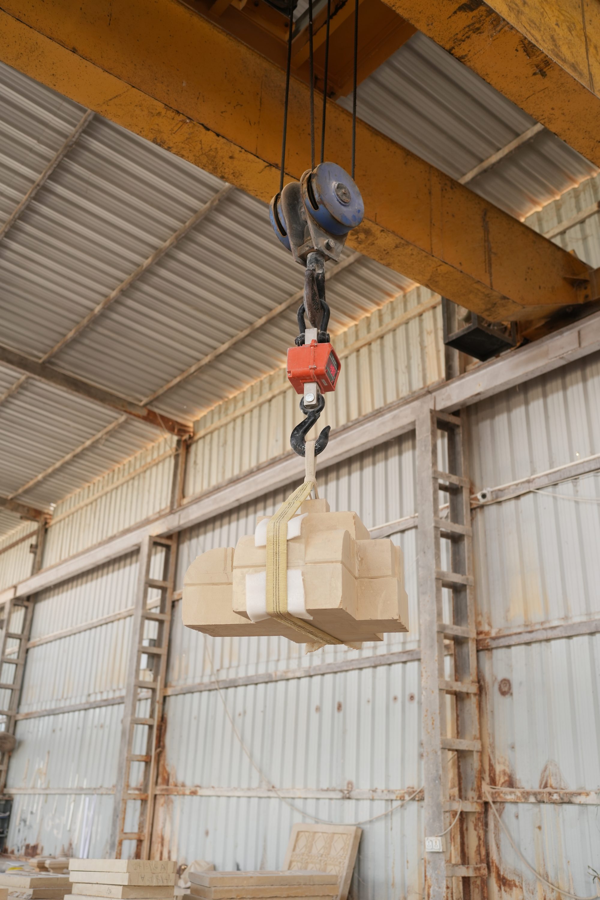 MTCPL gantry crane lifting a palletized stack of finished stone
